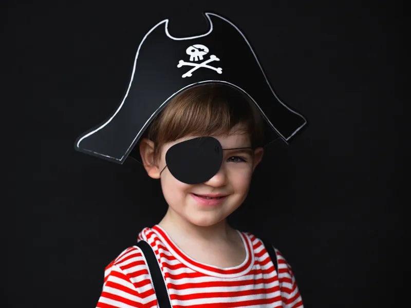 Chłopiec w czapce pirata z opaską na oku